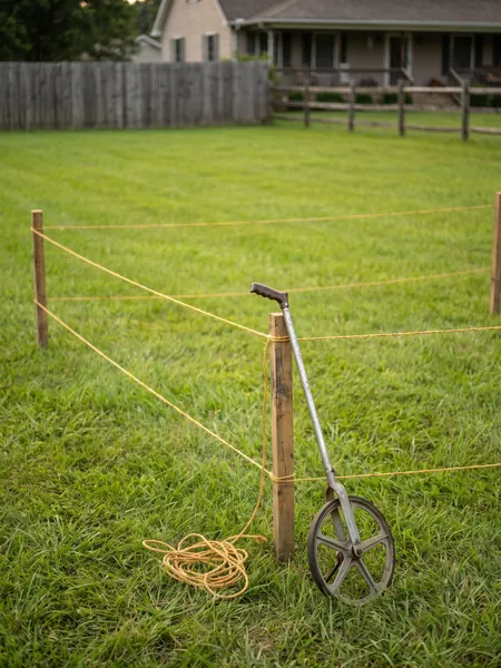 Measuring acreage Acreage calculator: field staked out with string lines to measure acres